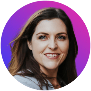 "A woman with long brown hair smiles warmly at the camera. She has light-colored eyes, and her skin is fair. She is wearing a light-colored shirt, and her hair is gently blowing to the side. The background is a gradient of purple transitioning to pink, giving a soft and colorful effect.