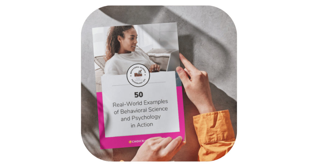A person in an orange shirt holds a book titled "50 Real-World Examples of Behavioral Science and Psychology in Action." The cover features an image of a woman sitting and looking at her laptop. The background shows a gray, sunlit surface. - Choice Hacking Academy A person in an orange shirt holds a book titled "50 Real-World Examples of Behavioral Science and Psychology in Action." The cover features an image of a woman sitting and looking at her laptop. The background shows a gray, sunlit surface.