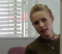 A blonde woman with a ponytail looks through a doorway into a room with a slightly confused expression. She is wearing a green top and a choker necklace. Behind her is a window with closed blinds and a pink chair. - Choice Hacking Academy A blonde woman with a ponytail looks through a doorway into a room with a slightly confused expression. She is wearing a green top and a choker necklace. Behind her is a window with closed blinds and a pink chair.