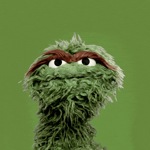A green puppet with shaggy fur and thick brown eyebrows shakes their head from left to right against a solid green background. - Choice Hacking Academy A green puppet with shaggy fur and thick brown eyebrows shakes their head from left to right against a solid green background.